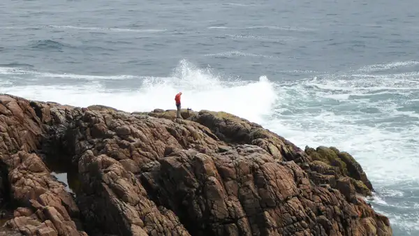 Man on a cliff at Fanad Head Lighthouse