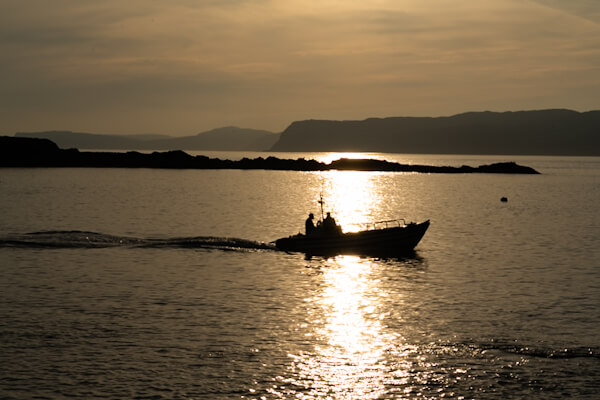 Small ferry boat at Ellenabeich Harbour at sunset
