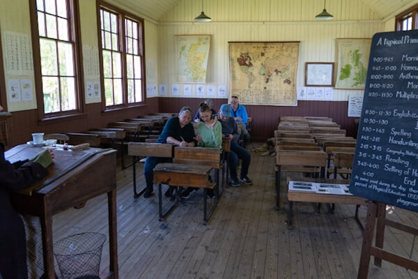 Visitors practicing writing at Highland Folk Museum school